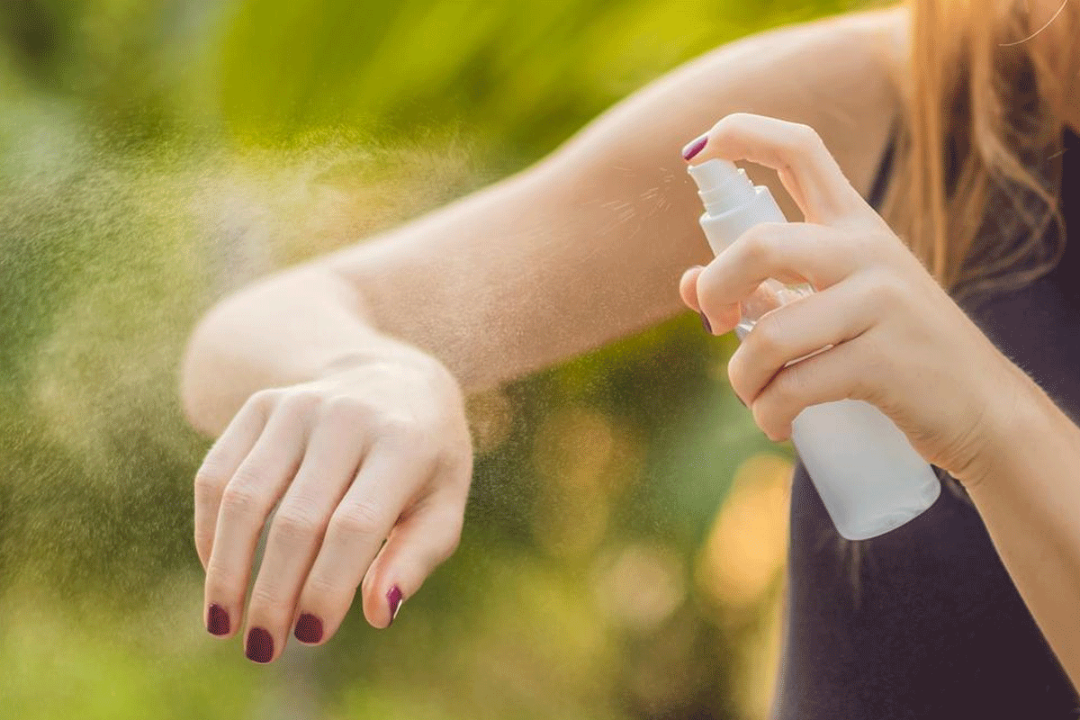 Woman spraying arm for Is bug spray flammable